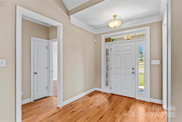 foyer entrance with light hardwood / wood-style floors and ornamental molding