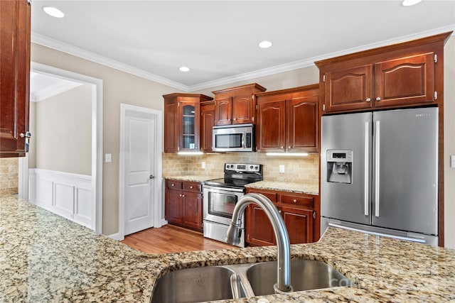 kitchen featuring tasteful backsplash, crown molding, sink, and appliances with stainless steel finishes