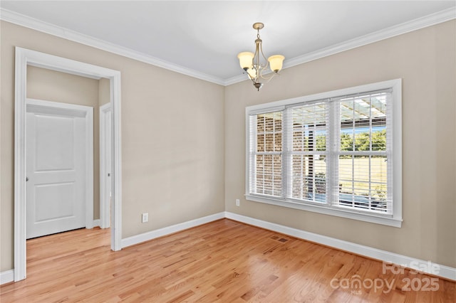 spare room featuring light wood-type flooring, crown molding, and a chandelier