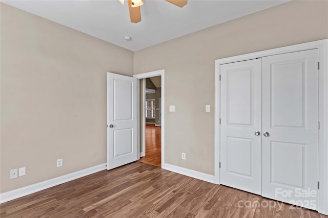 unfurnished bedroom featuring ceiling fan, a closet, and wood-type flooring