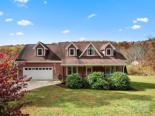 view of front of house with a front yard, a garage, and covered porch