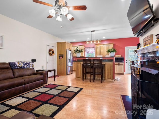 living room featuring ceiling fan and light wood-type flooring