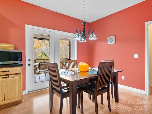 dining space with a chandelier and light wood-type flooring