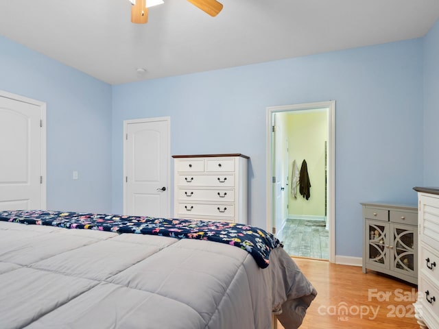 bedroom with ensuite bath, ceiling fan, and light wood-type flooring