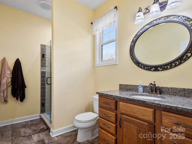 bathroom with hardwood / wood-style flooring, vanity, toilet, and a shower with shower door