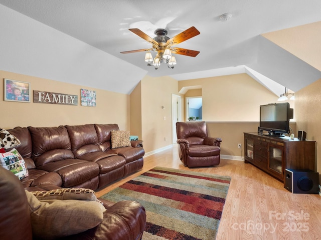 living room with ceiling fan, light wood-type flooring, and vaulted ceiling