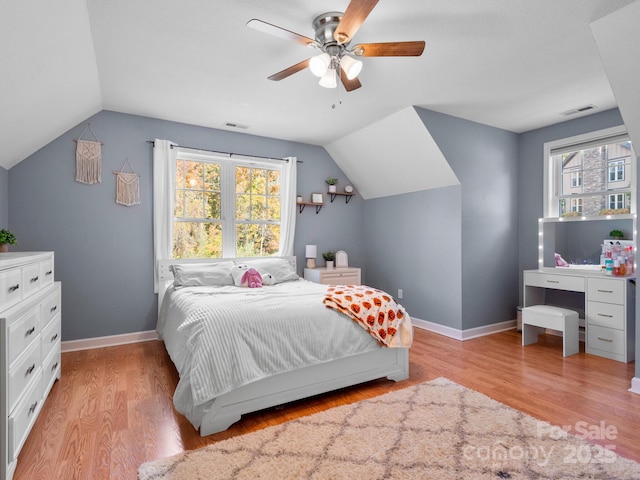 bedroom featuring ceiling fan, vaulted ceiling, light wood-type flooring, and multiple windows