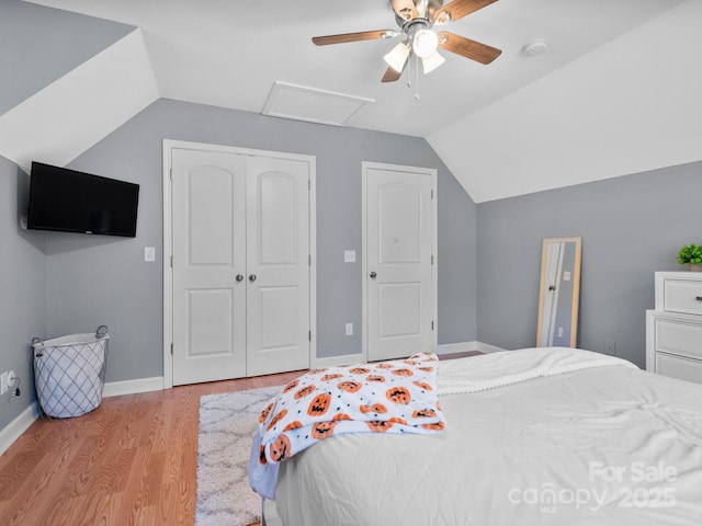 bedroom featuring ceiling fan, a closet, light hardwood / wood-style floors, and lofted ceiling