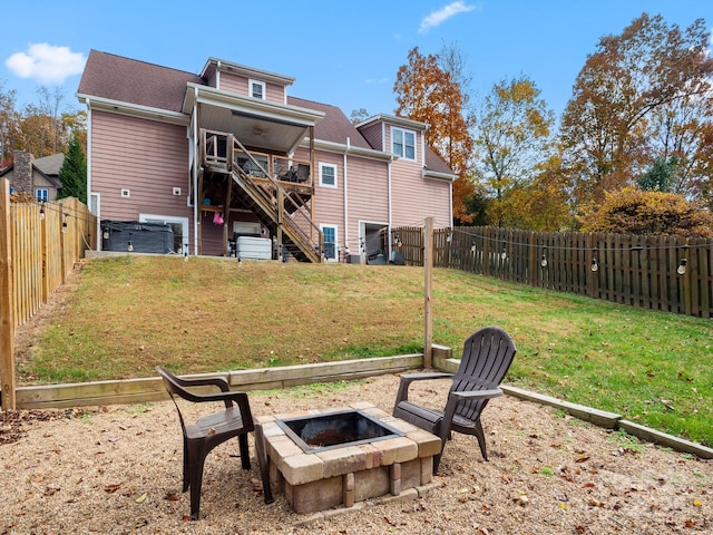 rear view of house featuring a yard, a fire pit, and a wooden deck