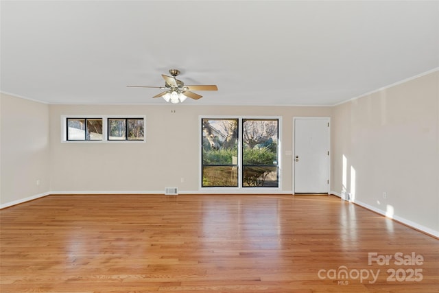 spare room with light wood-type flooring, plenty of natural light, ornamental molding, and ceiling fan