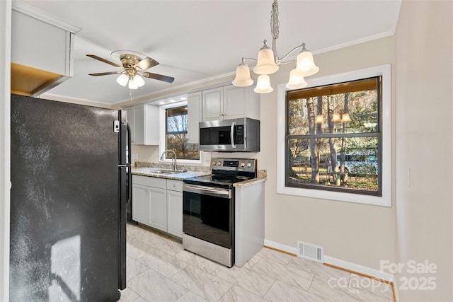 kitchen featuring white cabinets, ceiling fan with notable chandelier, crown molding, and appliances with stainless steel finishes