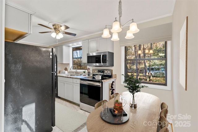 kitchen with white cabinets, pendant lighting, stainless steel appliances, and crown molding