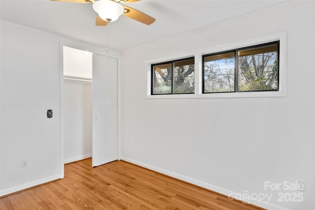 unfurnished bedroom with ornamental molding, a closet, ceiling fan, and light hardwood / wood-style floors