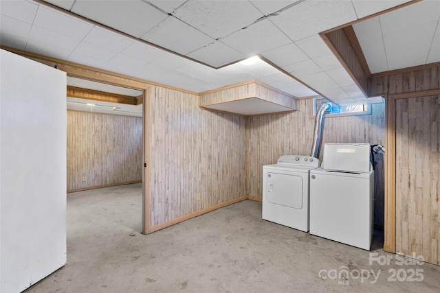 basement featuring washer and dryer and wood walls