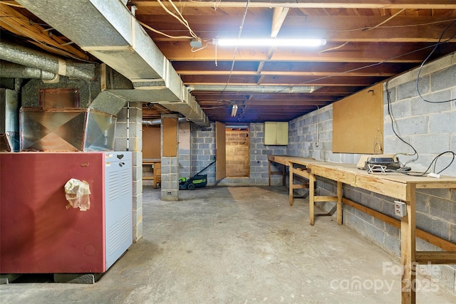 basement featuring a workshop area and heating unit