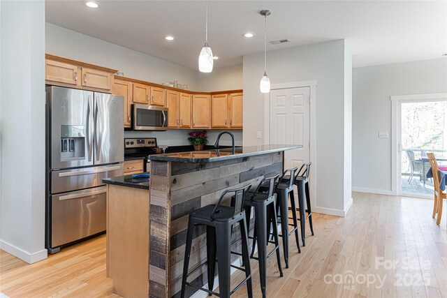 7 Pineview Rd, Fairview, NC 28730 - kitchen with stainless steel appliances, light wood finished floors, a breakfast bar area, a kitchen island with sink, and recessed lighting