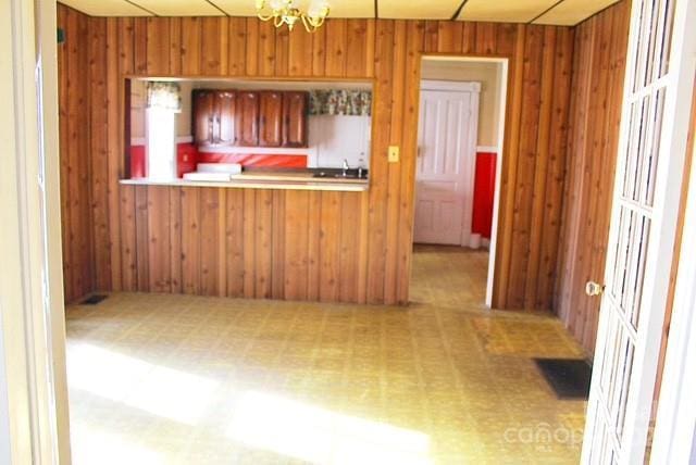 kitchen with kitchen peninsula and wooden walls