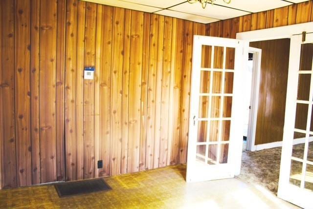 spare room with wood walls and french doors