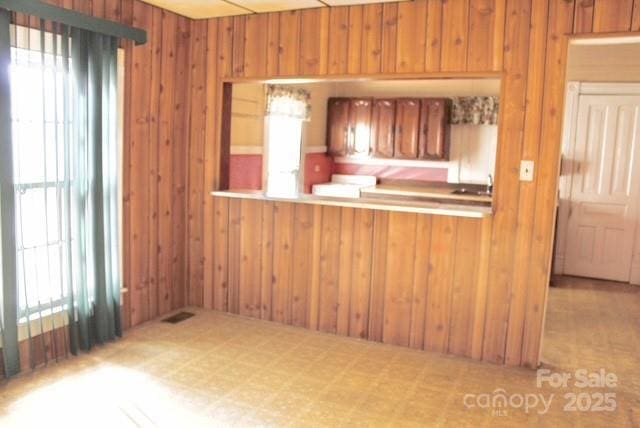 kitchen with kitchen peninsula and wooden walls