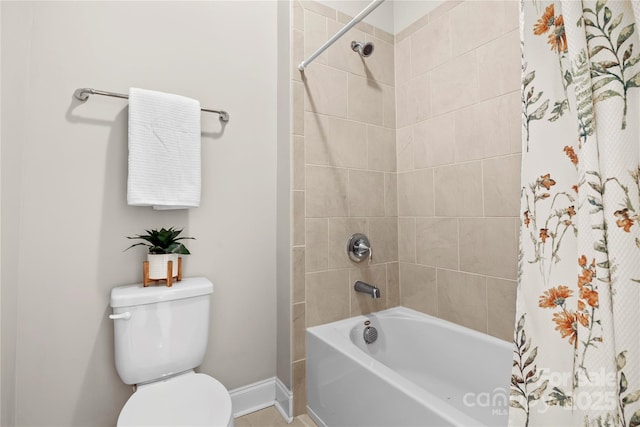 bathroom featuring tiled shower / bath combo and toilet