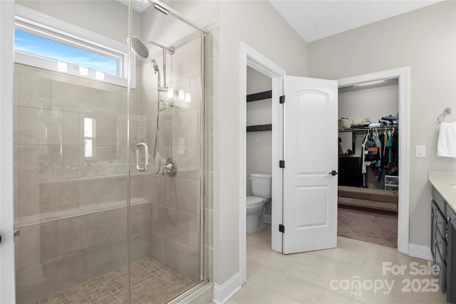 bathroom with tile patterned flooring, vanity, toilet, and an enclosed shower