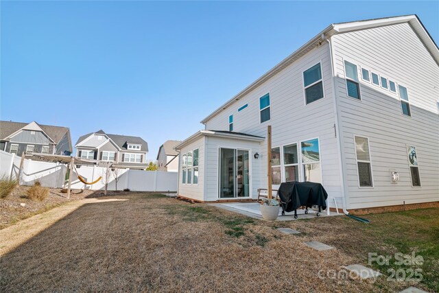 back of property featuring a lawn and a patio area