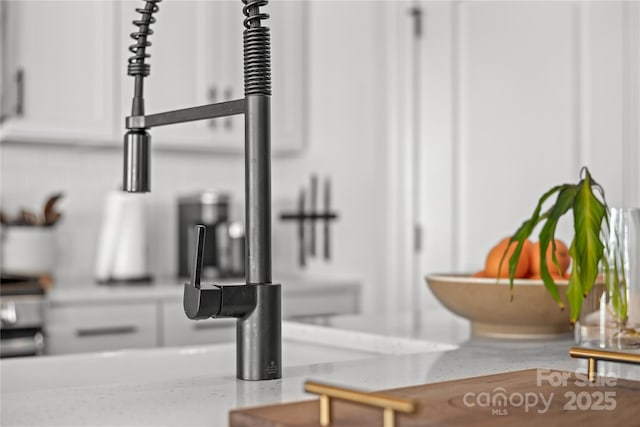 interior details with white cabinetry and sink