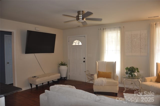 living room with ceiling fan and dark wood-type flooring