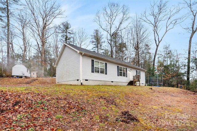 view of front of house with a trampoline and a storage shed