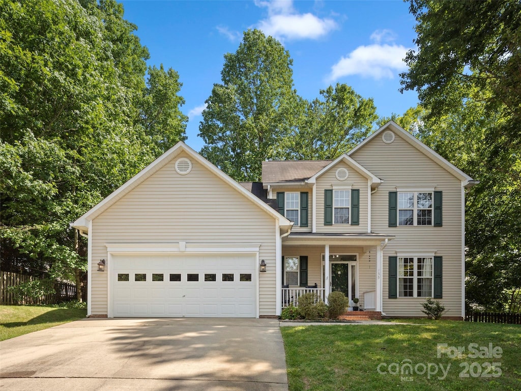 front of property featuring a front yard, a porch, and a garage