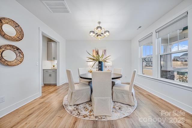 dining room featuring a notable chandelier and light hardwood / wood-style floors