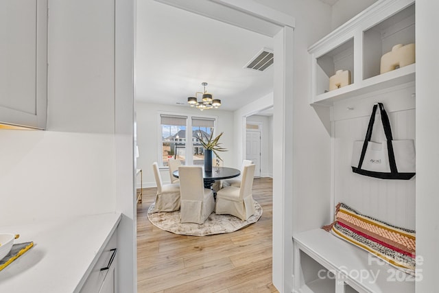 interior space with a notable chandelier and light hardwood / wood-style floors