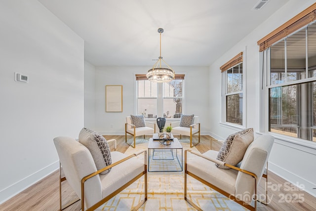 living room featuring light hardwood / wood-style floors and an inviting chandelier