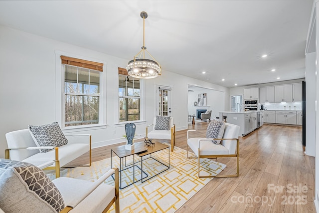 living room with light wood-type flooring and a chandelier