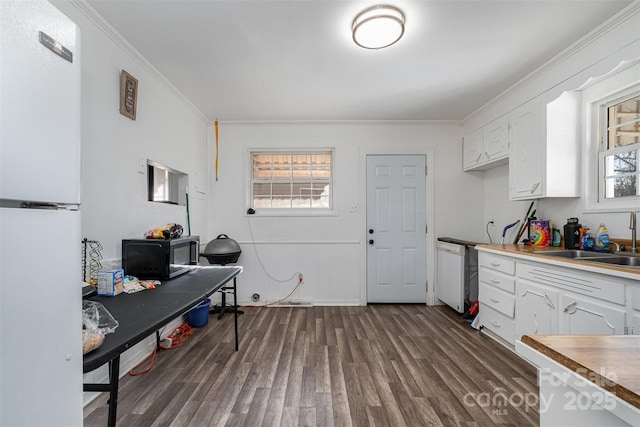 kitchen featuring sink, dark wood-type flooring, white refrigerator, white cabinets, and ornamental molding