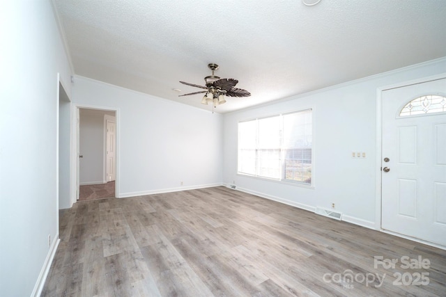 foyer with crown molding, light hardwood / wood-style flooring, ceiling fan, and a textured ceiling