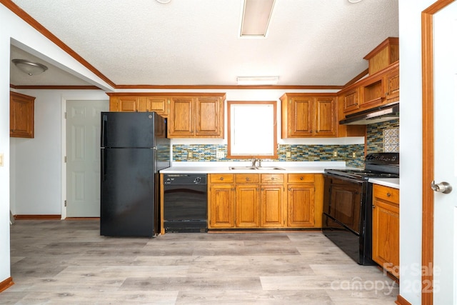 kitchen featuring black appliances, backsplash, sink, and light hardwood / wood-style flooring