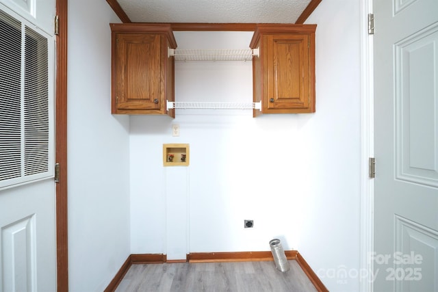 laundry area featuring hookup for a washing machine, a textured ceiling, ornamental molding, and electric dryer hookup