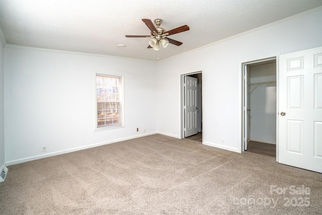 unfurnished bedroom with a textured ceiling, carpet floors, ceiling fan, and ornamental molding