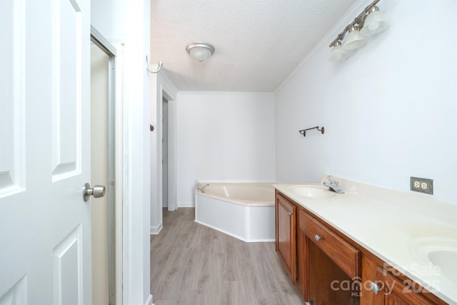 bathroom featuring vanity, a bath, a textured ceiling, and wood-type flooring