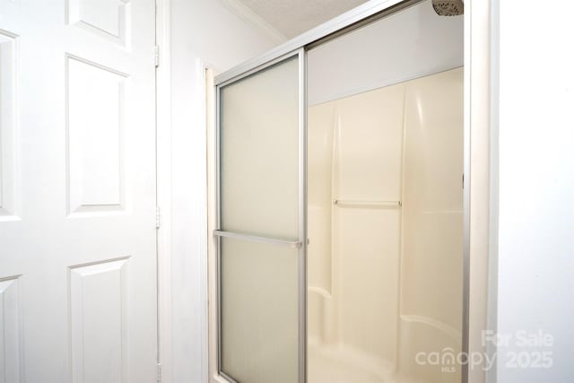 bathroom featuring an enclosed shower and a textured ceiling