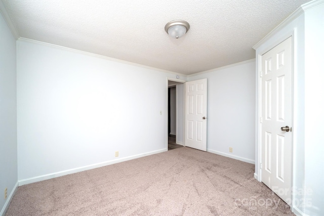 empty room with light carpet, a textured ceiling, and ornamental molding