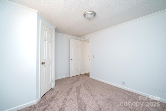 spare room with light carpet, a textured ceiling, and ornamental molding