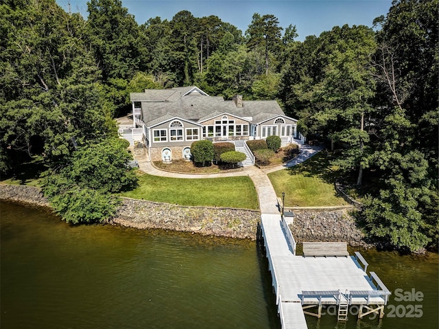 rear view of property with a yard and a water view