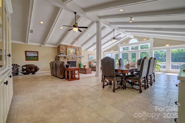 dining area with lofted ceiling with beams, ceiling fan, and a fireplace