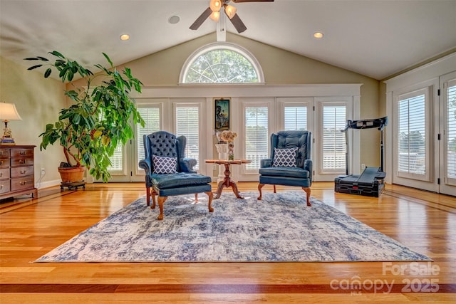 living area with ceiling fan, vaulted ceiling, and light wood-type flooring