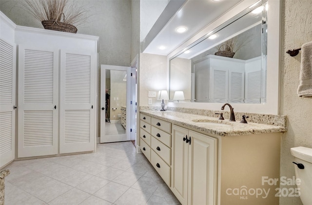 bathroom with tile patterned floors, vanity, toilet, and crown molding