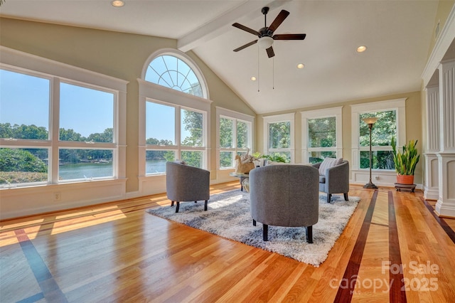 living room with ceiling fan, lofted ceiling with beams, a water view, and light wood-type flooring