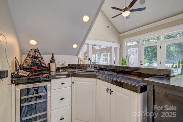 kitchen with white cabinetry, french doors, sink, wine cooler, and lofted ceiling