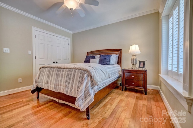 bedroom featuring ceiling fan, ornamental molding, light hardwood / wood-style flooring, and a closet